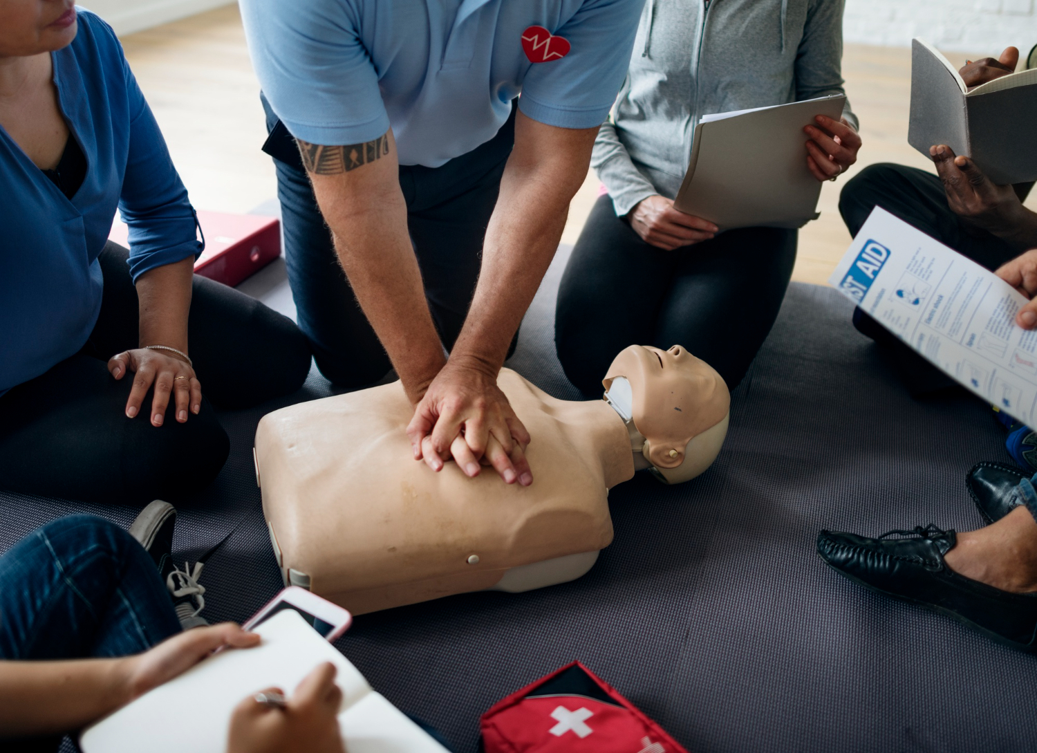 BHV cursus 3 Instructeur oefent reanimatie met een kleine groep tijdens een BHV cursus van 5 uur