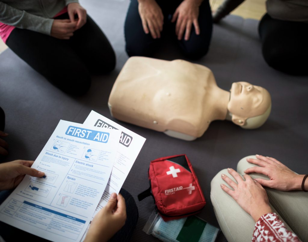 Deelnemers met lesmateriaal bij de reanimatiepop tijdens de BHV cursus voor het BHV diploma